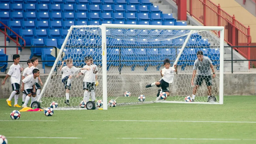 Ein Trainer der DFB-Akademie erklärt einem jungen Spieler eine Technik während des Trainings