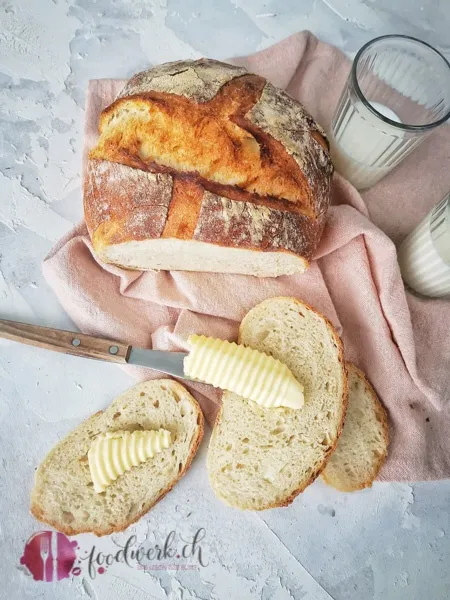 Ein warmes Stück Hausbrot mit Butter bestrichen