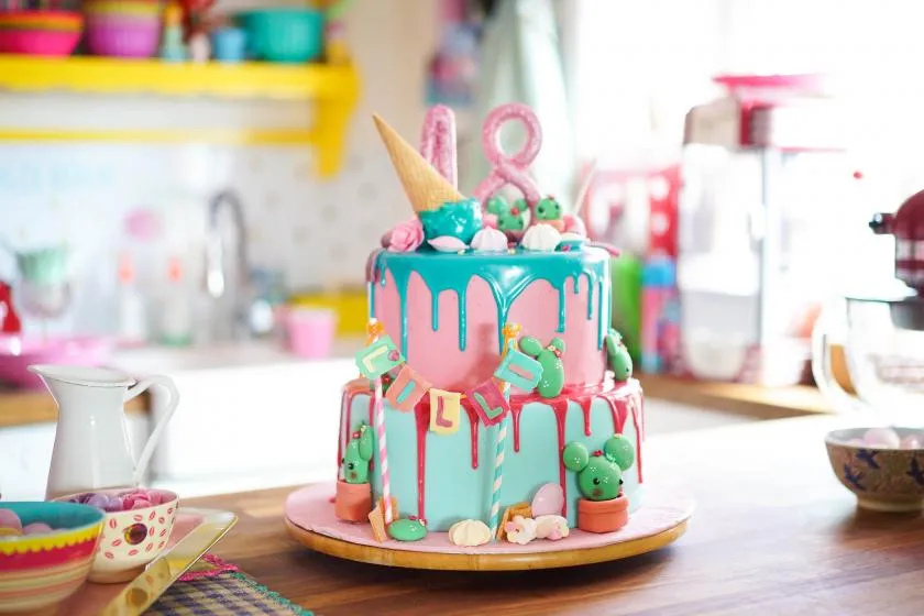 Eindrucksvoller zweistöckiger Candy Drip Cake, anpassbar für jeden Kindergeburtstag.