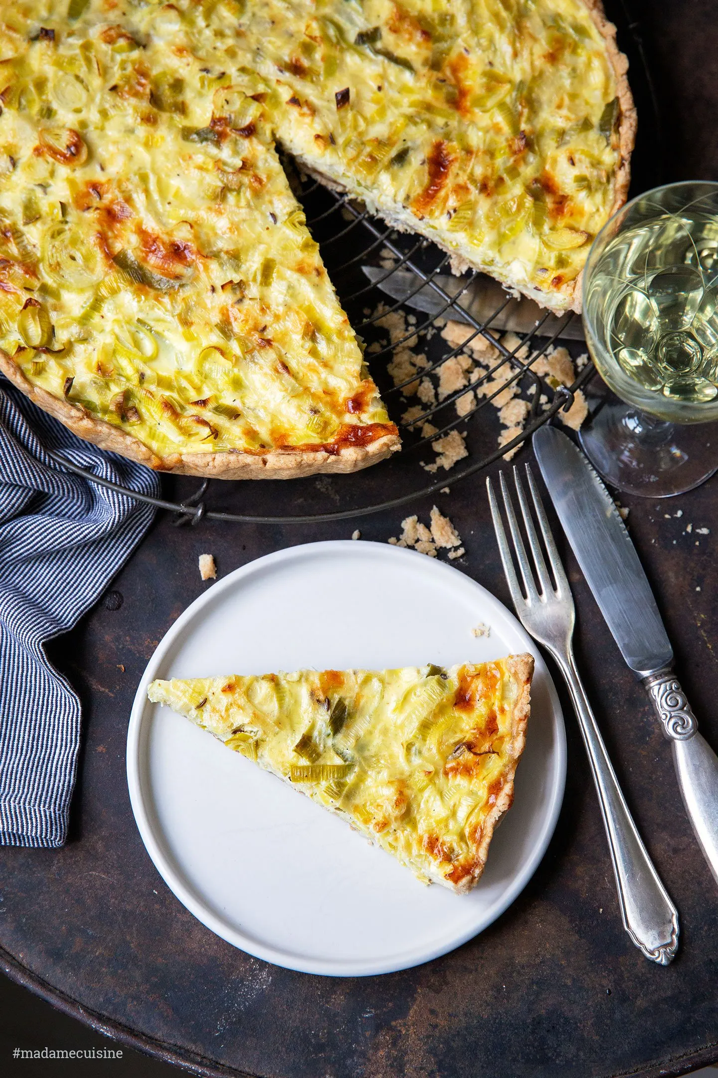 Eine angeschnittene Lauch Quiche, die ihre cremige Füllung und den knusprigen Teig offenbart