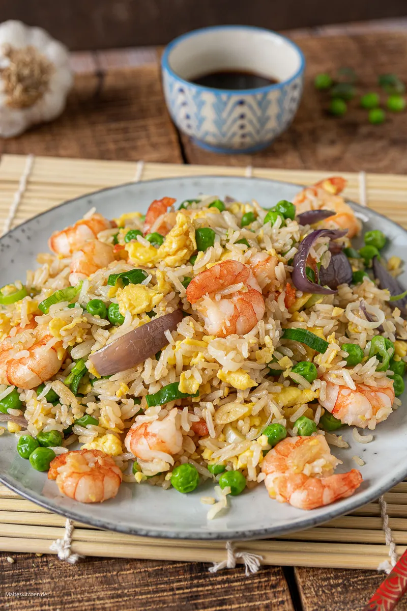 Eine asiatische Reispfanne mit Garnelen, Ei und Gemüse im Wok.