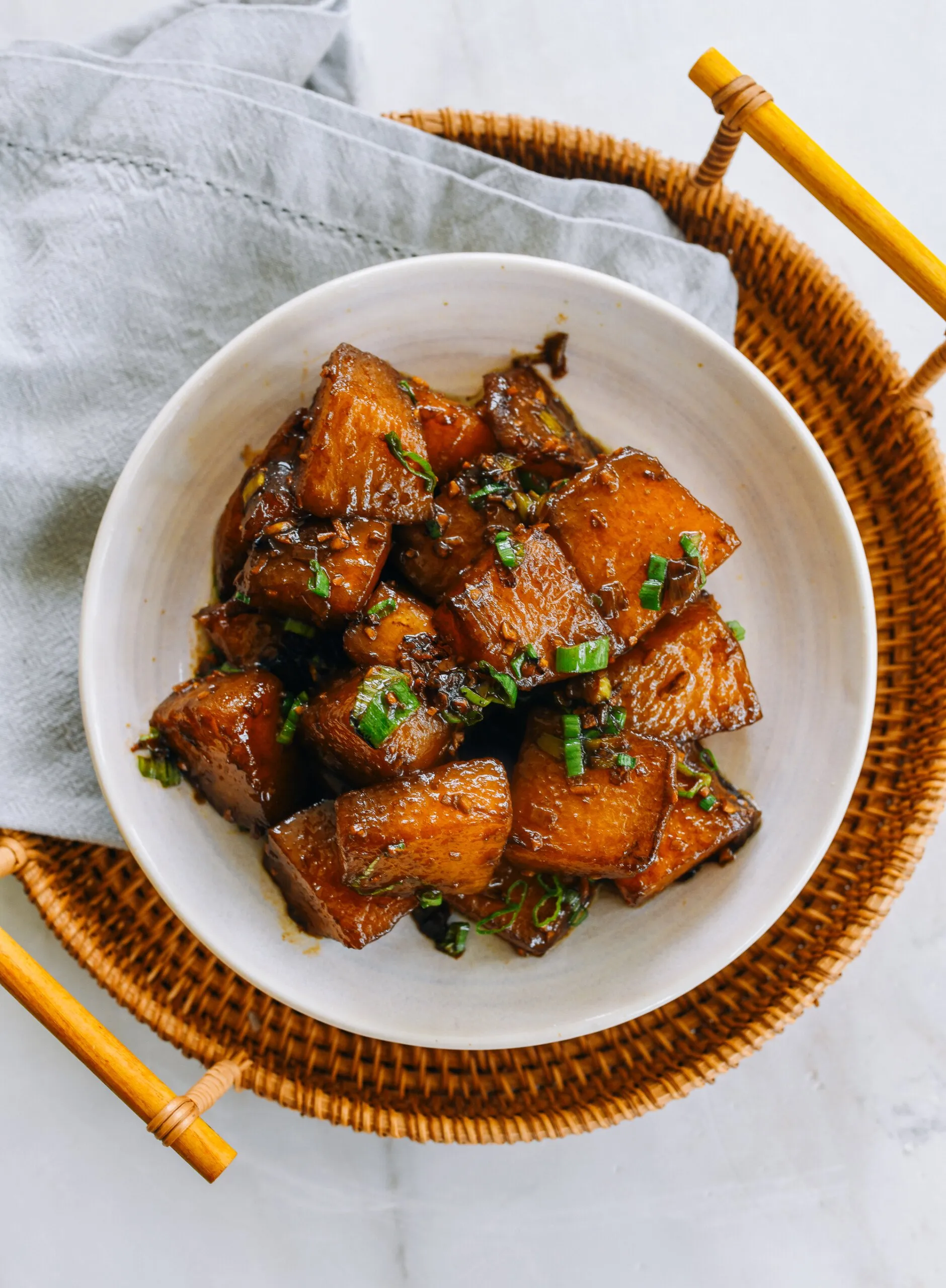 Eine dampfende Schale Gulaschsuppe mit frischer Petersilie garniert auf einem Holztisch