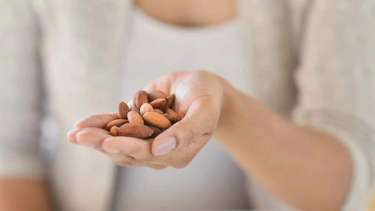 Eine Frau hält Mandeln in ihrer Hand
