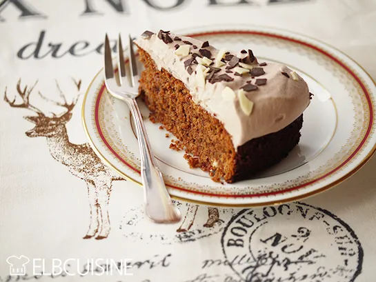 Eine ganze Amarettini-Schoko-Sahne-Torte auf einem weißen Tortenständer