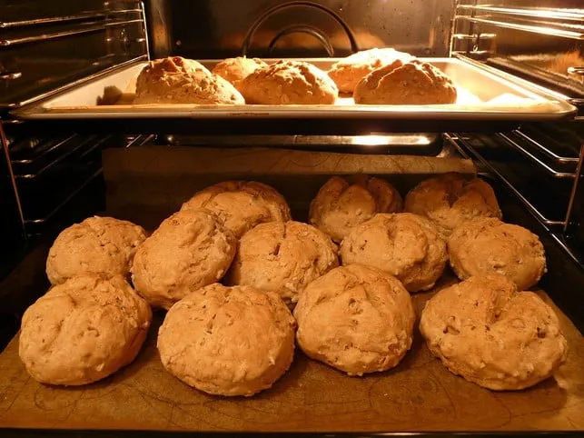 Eine größere Menge Brötchen wird im Backofen aufgebacken, um knusprig und warm zu werden.
