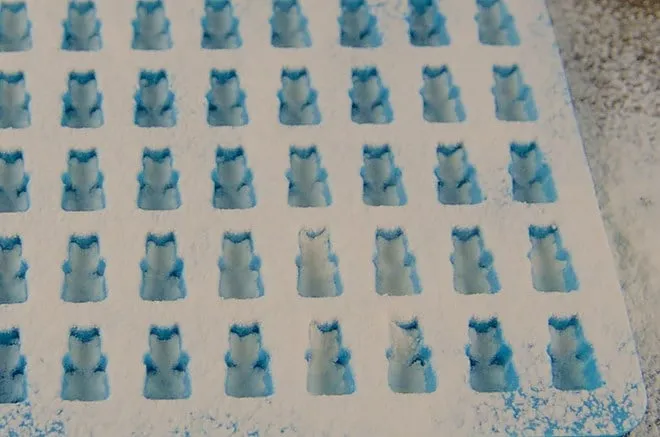 Eine Gummibärchen-Form wird mit Speisestärke vorbereitet.