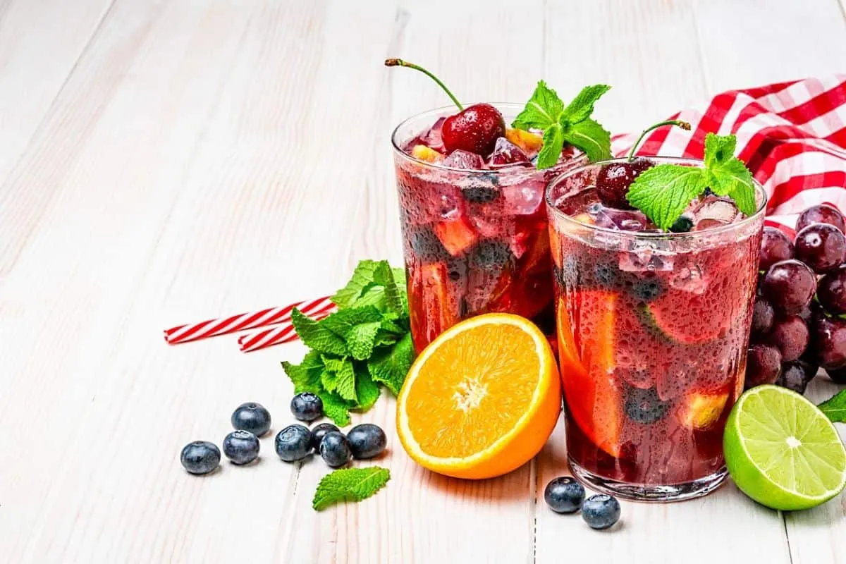 Eine Karaffe Sangria mit verschiedenen Früchten und Eis.