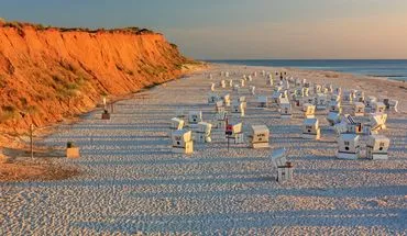 Eine malerische Küstenlandschaft in Norddeutschland mit Dünen und blauem Himmel, die zur Erholung einlädt.