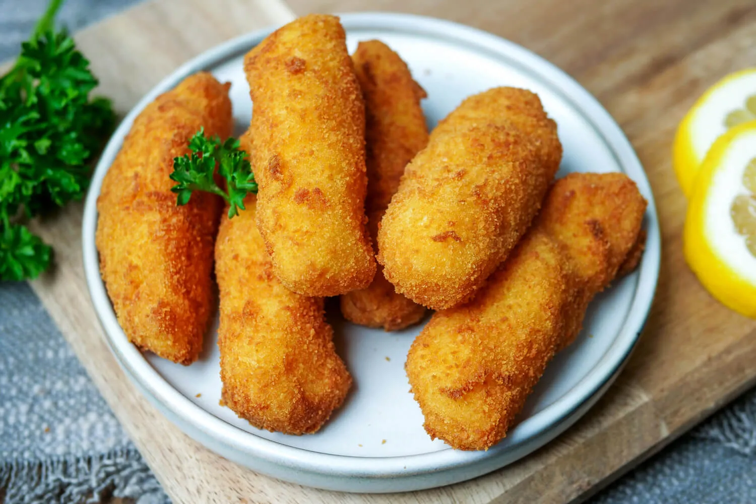 Eine Nahaufnahme von Kroketten auf einem weißen Teller, fertig zum Servieren.