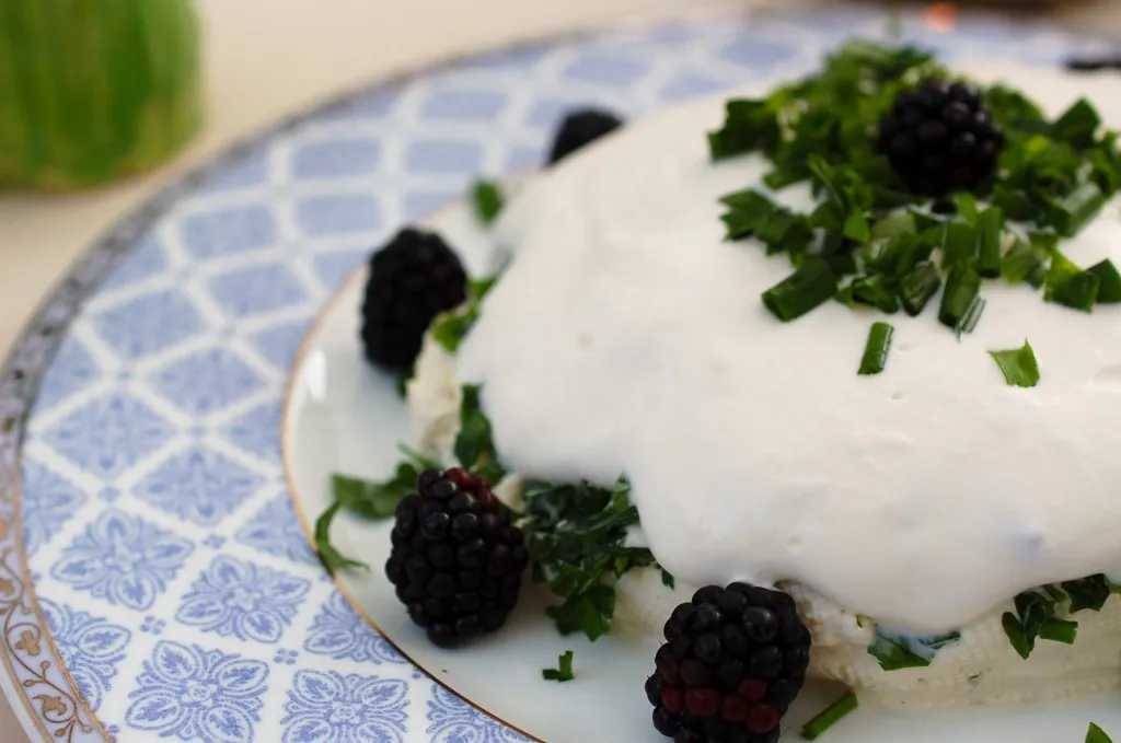 Eine Schale mit perfekt angerichteter Frischkäse-Creme, umgeben von Toastbrot und frischen Salatherzen