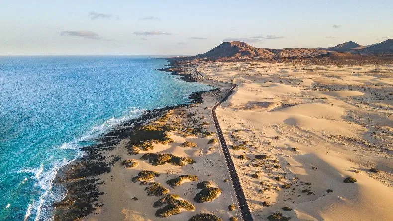 Endloser Sandstrand mit türkisfarbenem Wasser auf Fuerteventura.