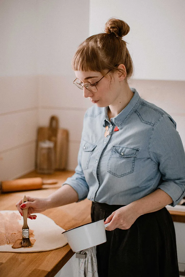 Eng aufgerollter Hefeteigstrang mit Zimtfüllung, bereit zum Schneiden in einzelne Zimtschnecken.