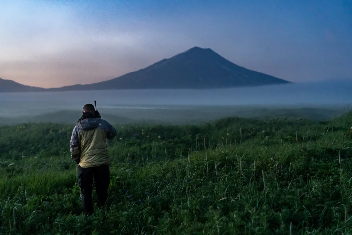 Expeditionsleiter telefoniert mit Satellitentelefon für Wettervorhersage