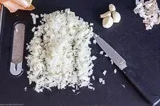 Fein gewürfelte Zwiebeln und geschälte Knoblauchzehen, bereit für die Zubereitung der Cevapcici