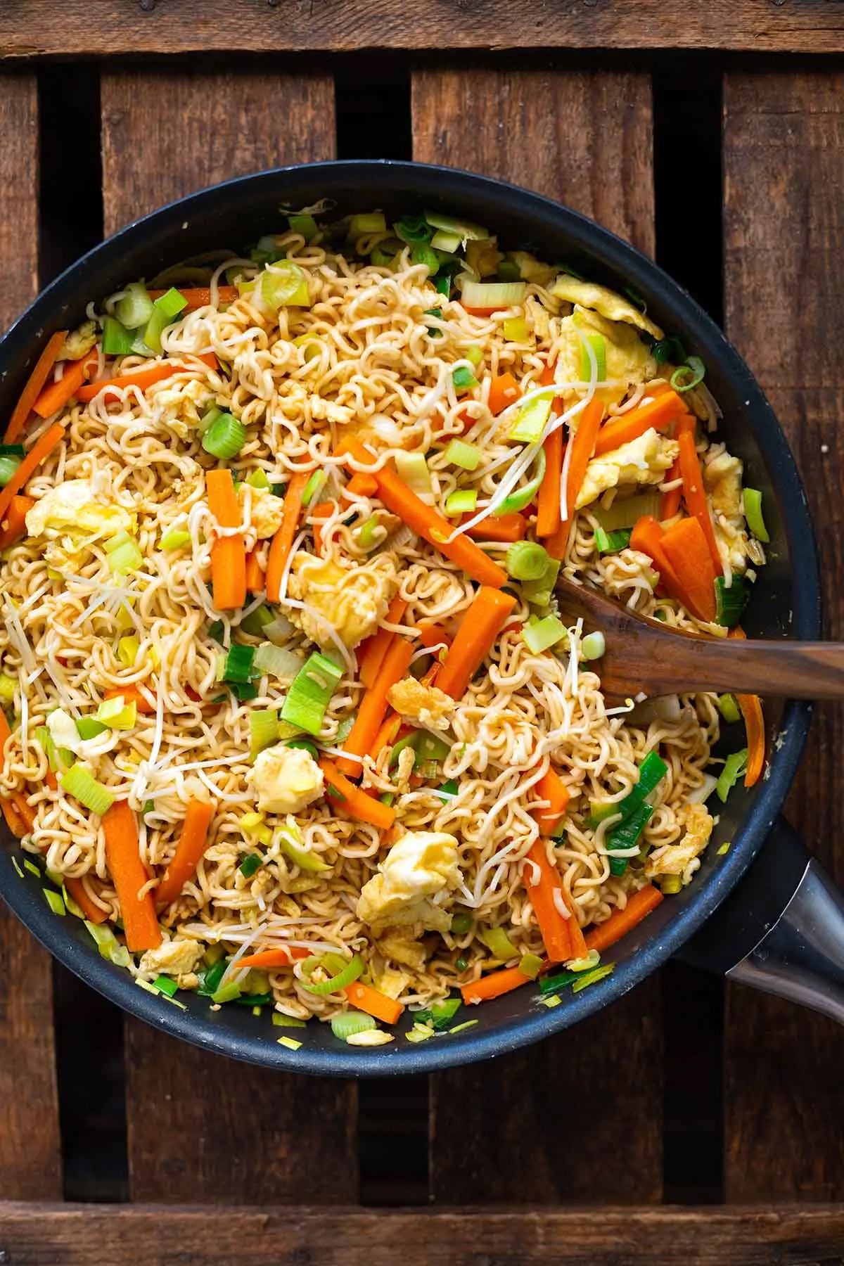 Fertige chinesische gebratene Nudeln mit Gemüse und Ei mit viel Gemüse in fertig gemischt in einer großen Pfanne.