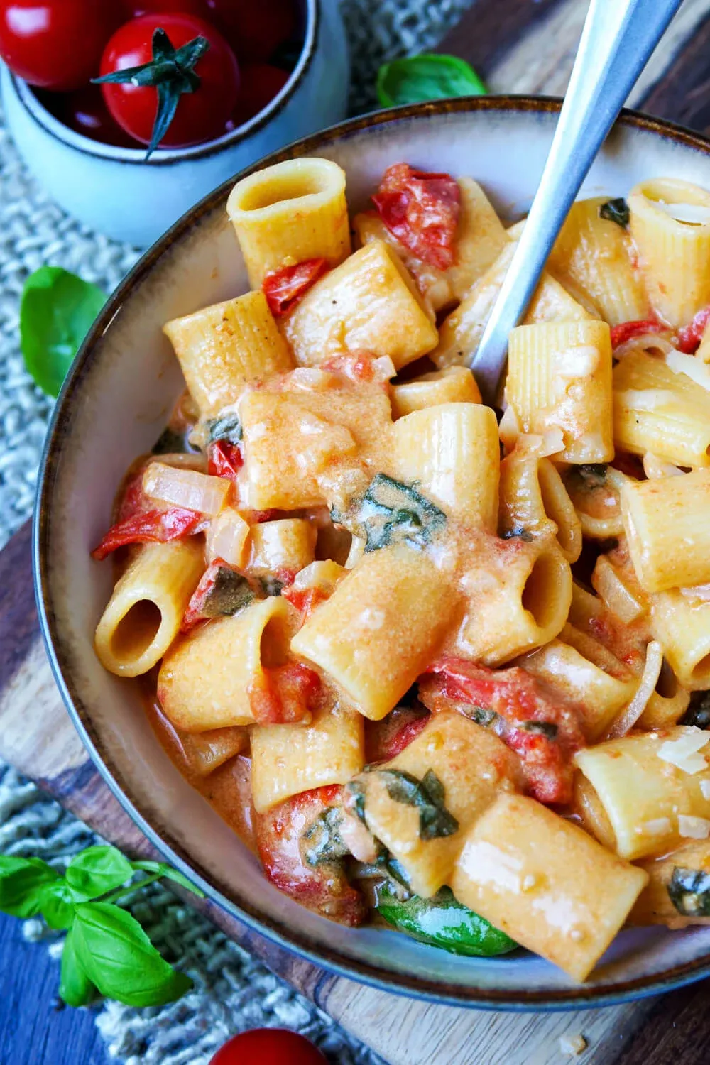 Fertige One Pot Pasta mit Tomaten, Basilikum und Parmesan auf einem Teller.