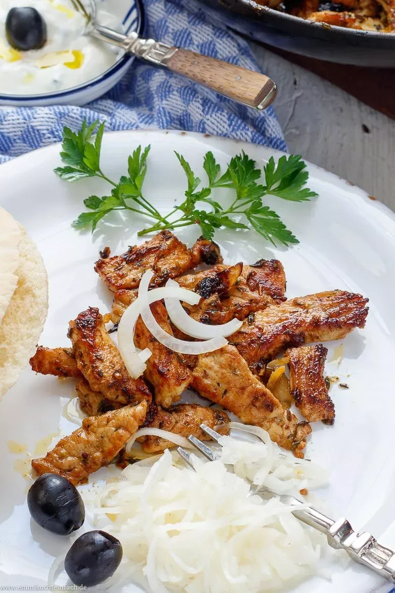 Fertiges Gyros auf einem Teller mit Beilagen wie Pommes und Tzatziki