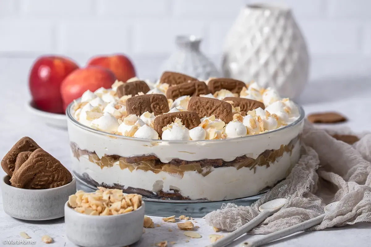 Fertiges Spekulatius Bratapfel Tiramisu, reichlich mit Schlagsahne, Spekulatiusbröseln und Mandeln garniert