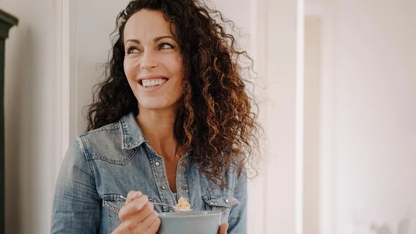 Frau isst Müsli mit Haferkleie zum Frühstück für einen gesunden Start in den Tag
