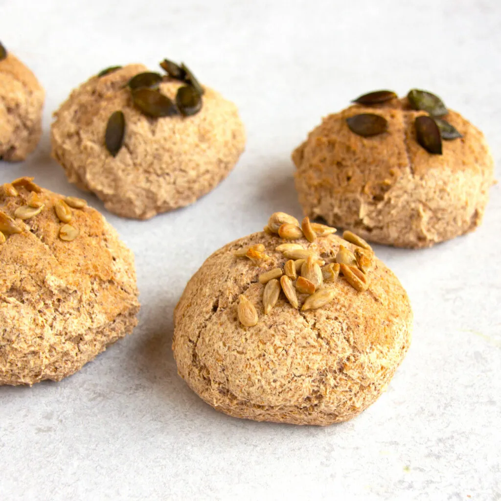 Frisch gebackene Buchweizenbrötchen auf einem Backblech mit Leinsamen bestreut