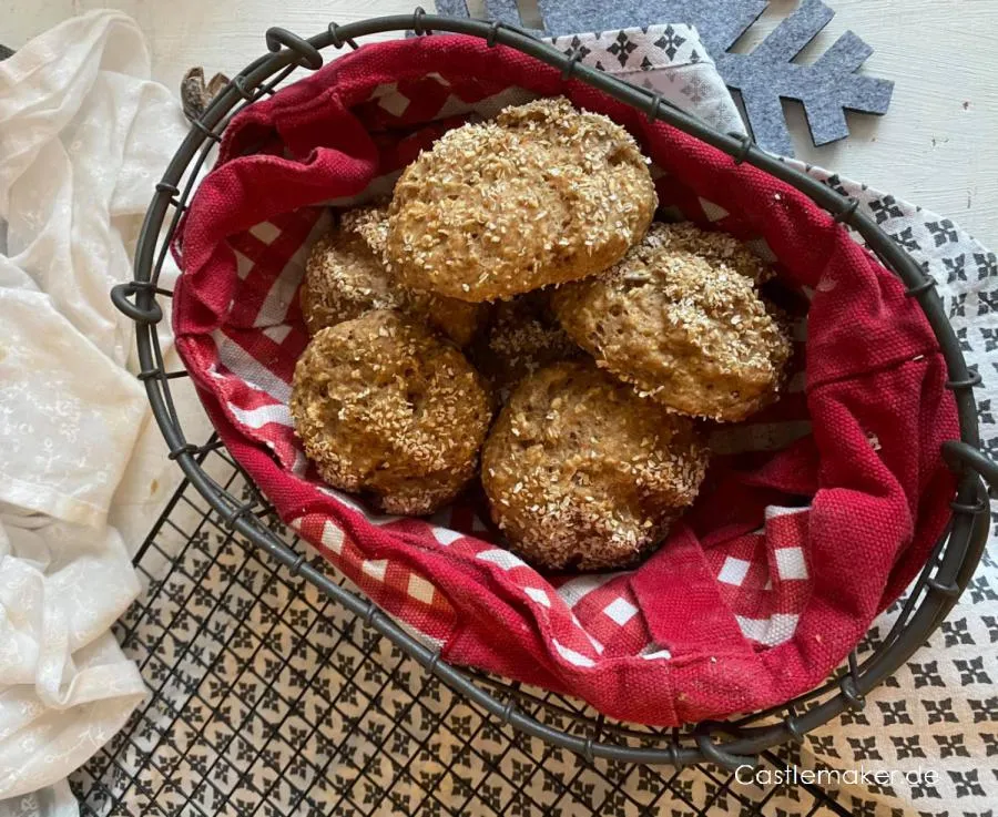 Frisch gebackene Dinkel-Hafer-Quarkbrötchen mit goldbrauner Kruste auf Backpapier