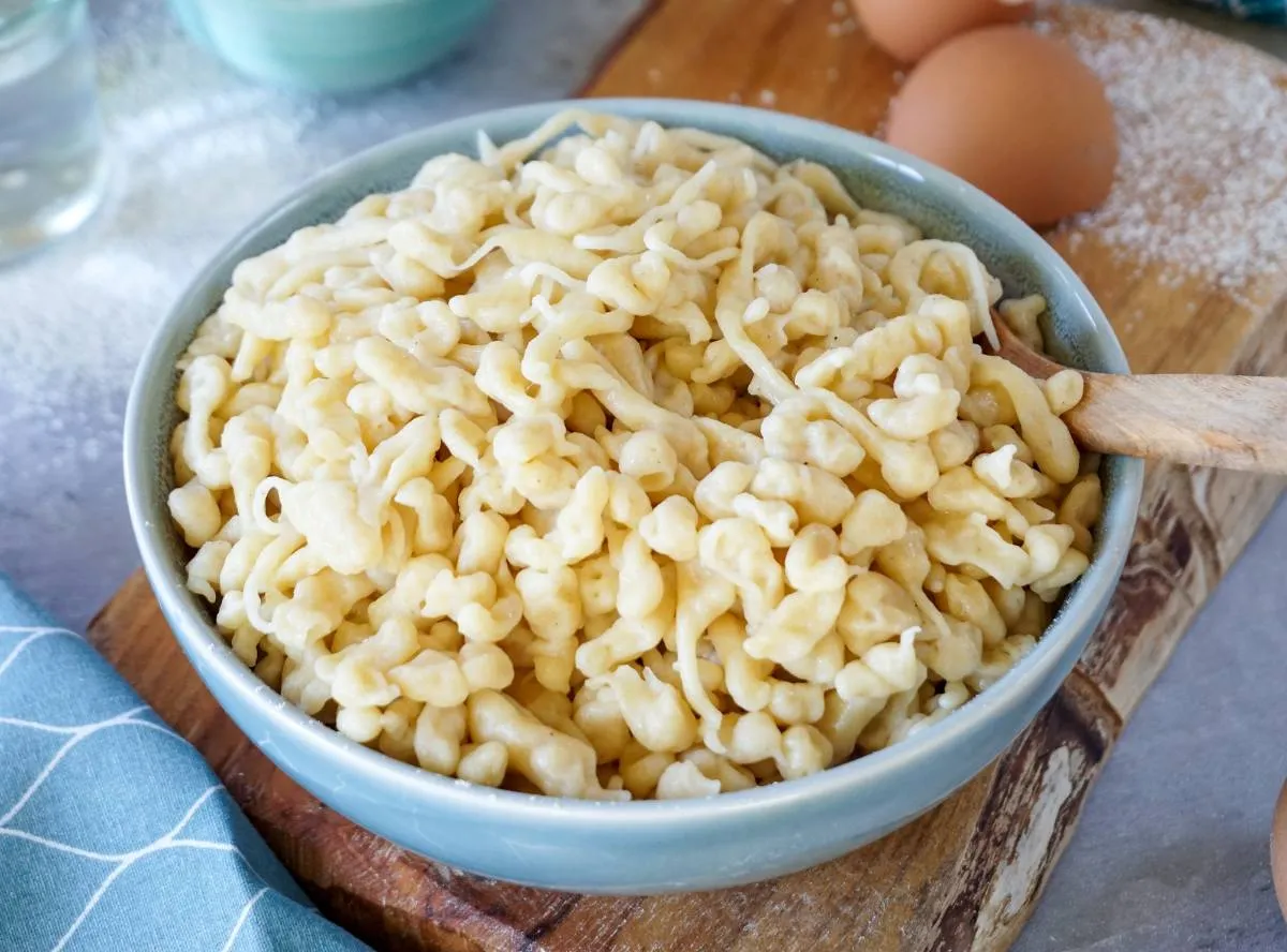 Frisch gemachte Spätzle auf einem Spätzlebrett, bereit zum Kochen