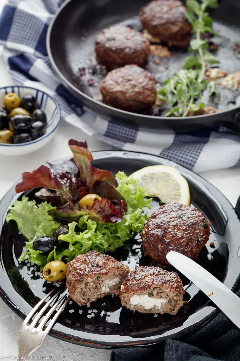 Frische Bifteki Frikadellen vor dem Braten mit gewürfeltem Feta