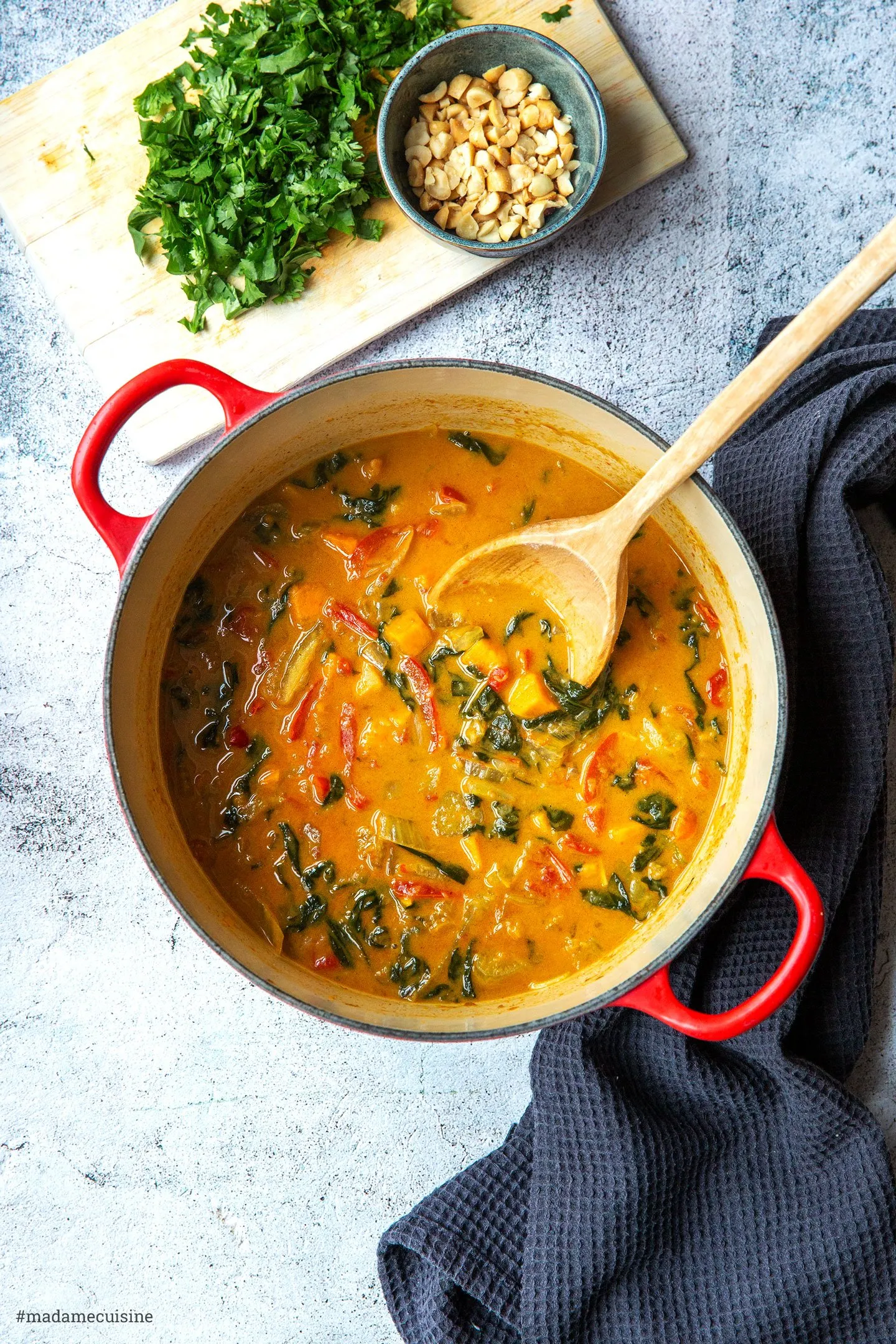 Frische Zutaten für ein Süßkartoffel-Curry: Süßkartoffeln, Paprika, Spinat und Gewürze