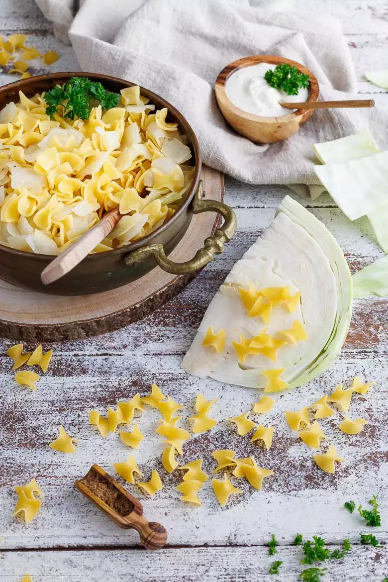 Frische Zutaten für Krautfleckerl auf einem Schneidebrett arrangiert