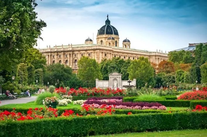 Frühlingslandschaft in Wien mit einem blühenden Park im Vordergrund und historischen Gebäuden im Hintergrund