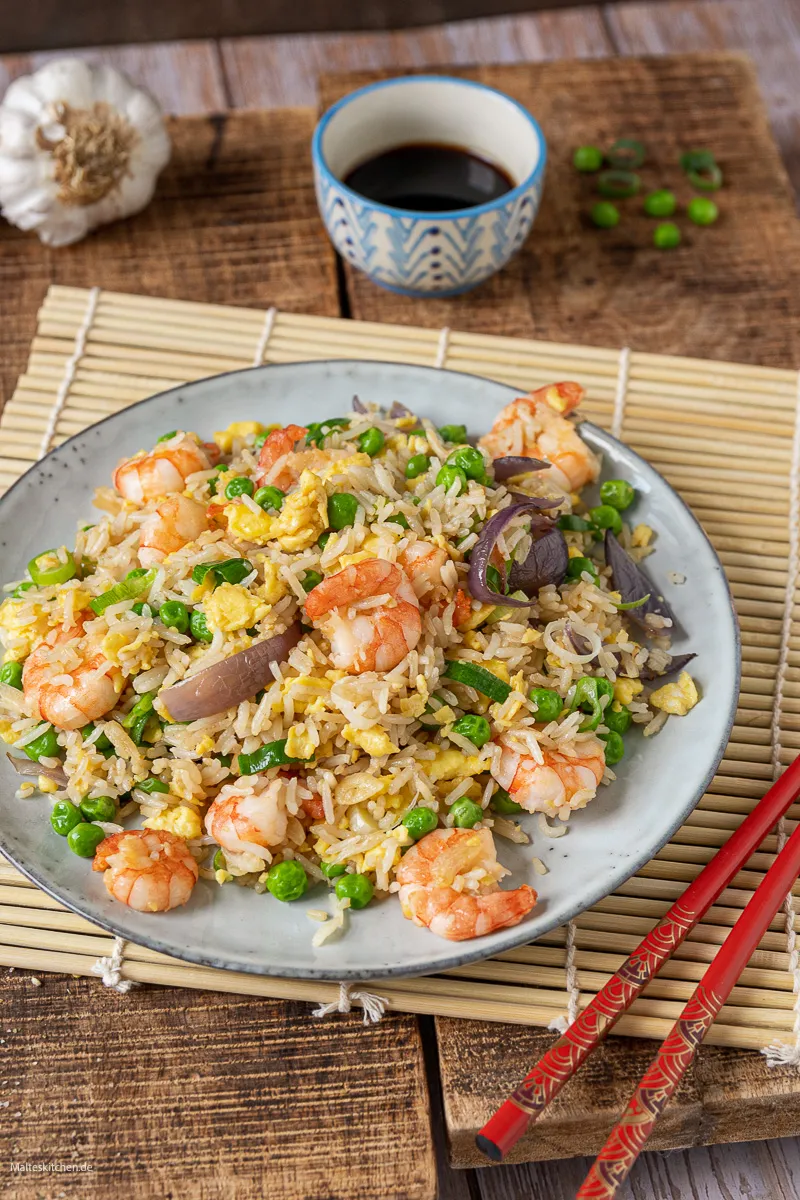 Gebratener Reis mit Gemüse, Ei und Garnelen serviert in einer Schale.
