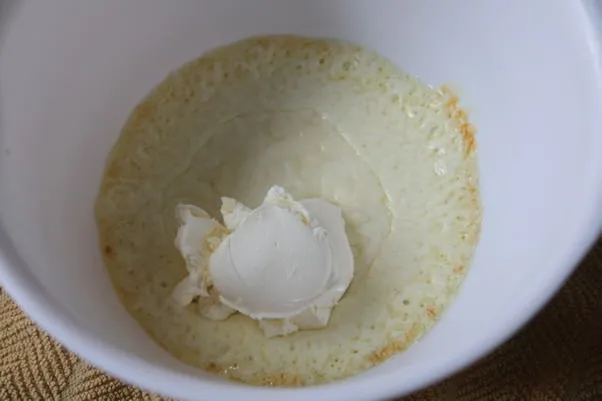 Geschmolzener Mozzarella mit Frischkäse und Ei, bereit zum Vermischen für den Pizzaboden