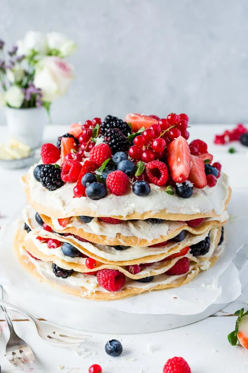 Gestapelte Pfannkuchentorte mit Beeren und Frischkäsecreme, eine beliebte Alternative zum Kuchen.