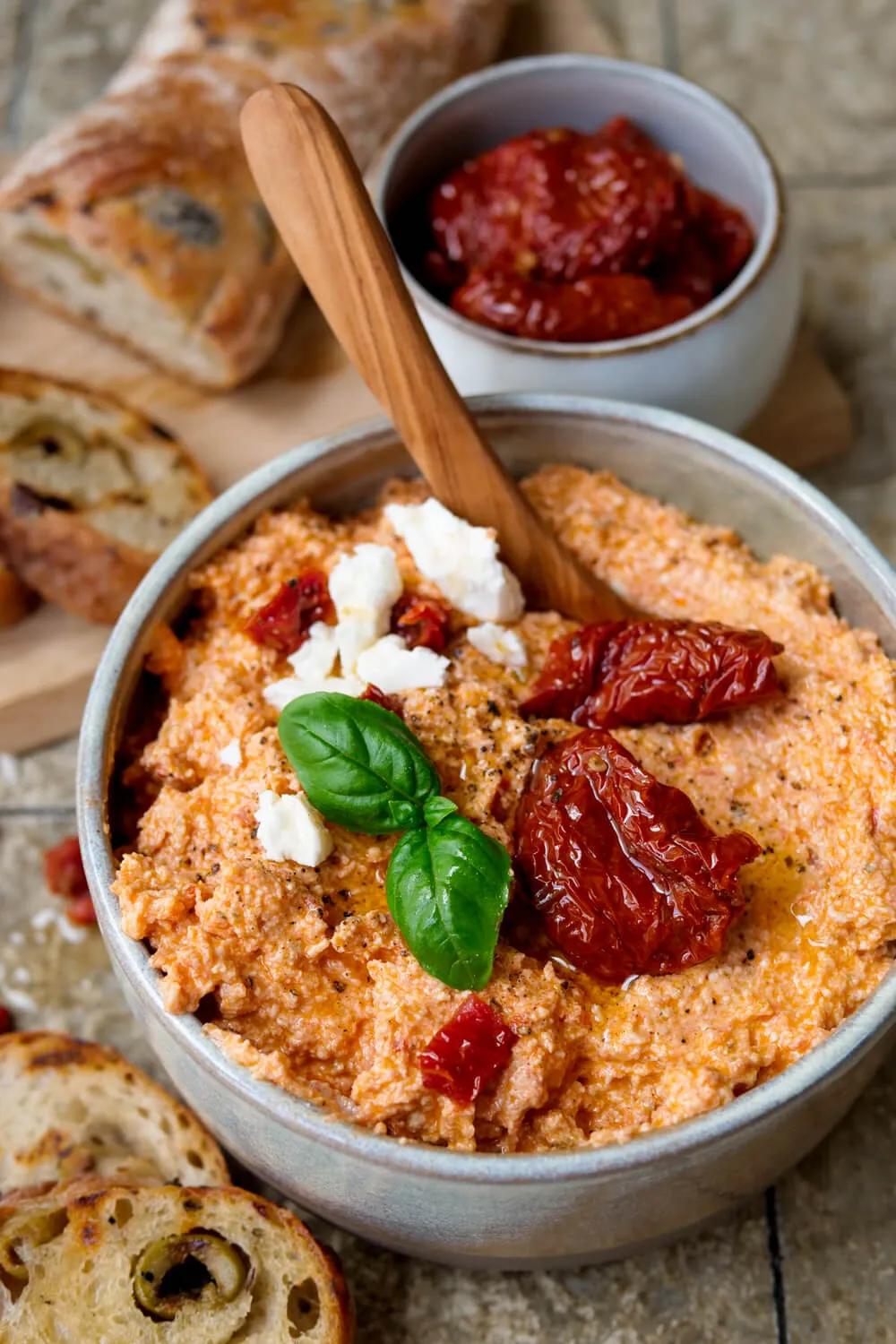 Getrocknete-Tomaten-Feta-Dip mit Olivenbaguette und Basilikum