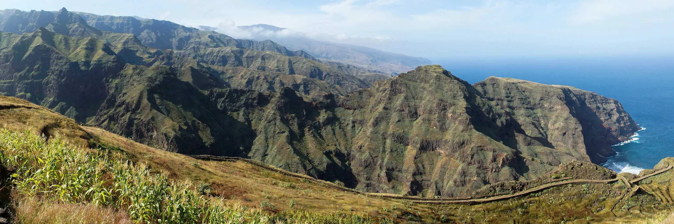 Grüne Küstenlandschaft der Kapverden mit steilen Klippen und klarem Himmel, perfekt zum Wandern