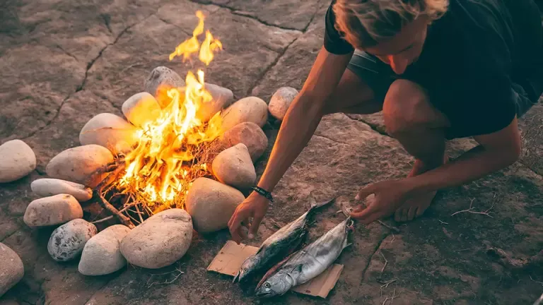 Gruppe von Surfern genießt ein gemütliches BBQ am Strand unter dem Sternenhimmel Marokkos