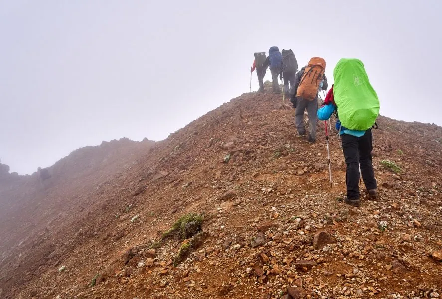 Gruppe wandert entlang eines Flusses in Kamtschatka, bedeckt vom Kaspersky Sky