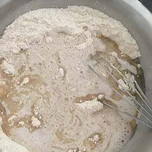 Hafermilch und Pflanzenöl werden zu den trockenen Zutaten gegeben