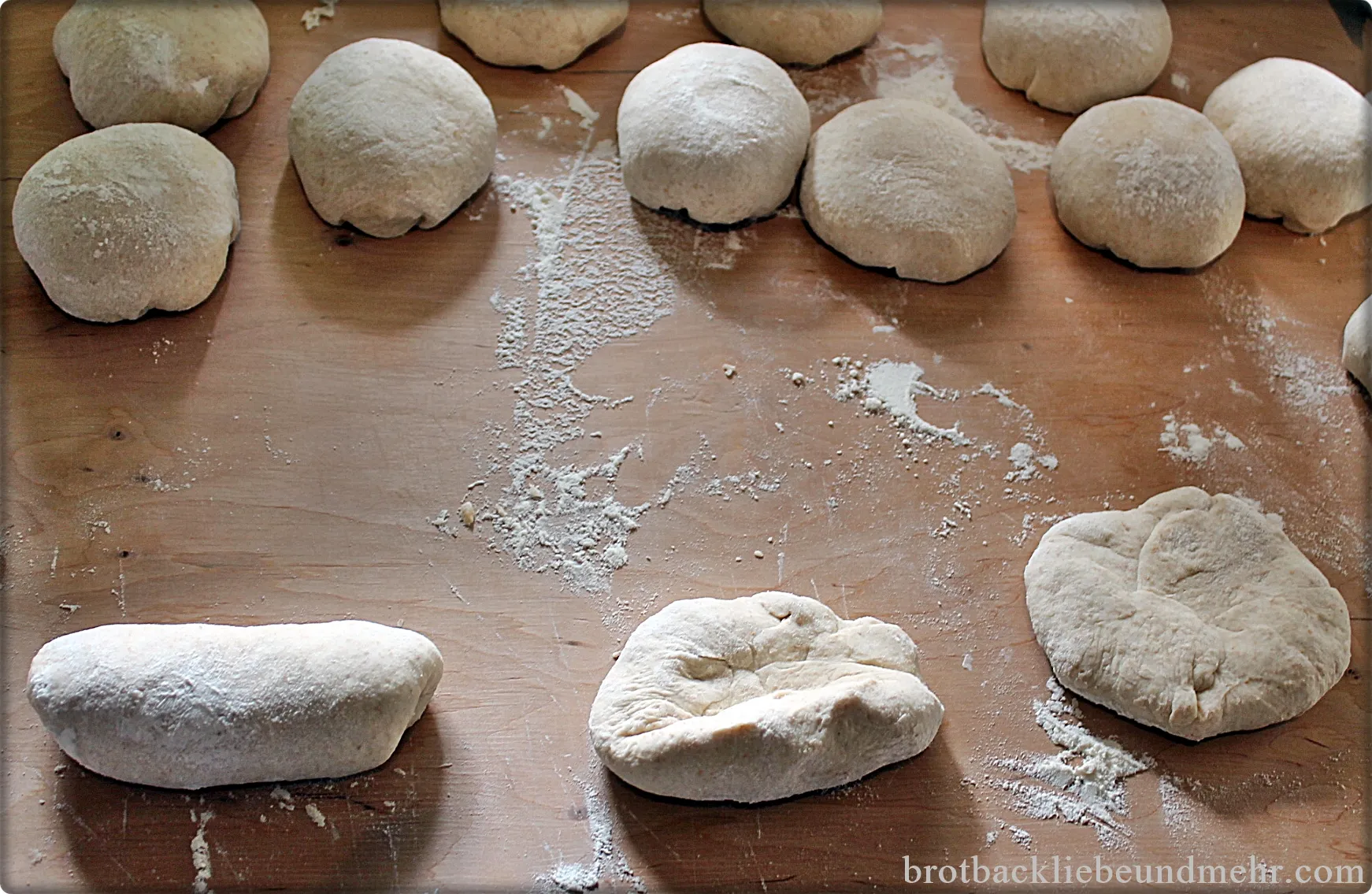 Hände, die Teiglinge zu kleinen Baguettes rollen, um die typische Form zu erhalten
