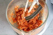 Hände kneten die Hackfleischmasse für Cevapcici in einer großen Schüssel, um die perfekte Konsistenz zu erreichen