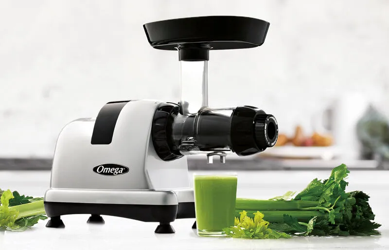 Hochwertiger Entsafter mit buntem Gemüse auf einer edlen Arbeitsfläche, perfekt für die Zubereitung erfrischender Säfte.