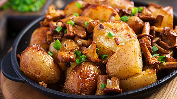 Kartoffel-Pfifferling-Pfanne mit Frühlingszwiebeln, servierfertig in der Pfanne