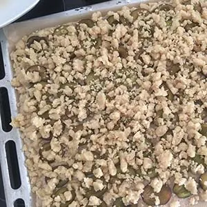 Knusprige Streusel werden großzügig über die Pflaumen gestreut