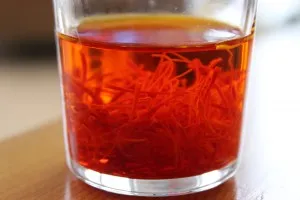 Kostbare Safranfäden in heißem Wasser, um ihr Aroma für die Safran-Orangensauce der Spinat Lachs Lasagne freizusetzen.