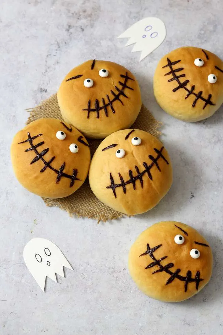 Kreative Halloween Brötchen Deko: Brötchen mit Schoko-Gesichtern und Zuckeraugen.