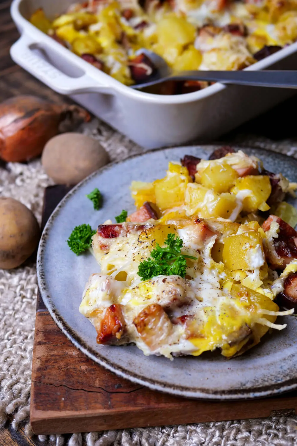 Leberkäse-Auflauf mit Kartoffeln und geschmolzenem Käse, angerichtet auf einem Teller