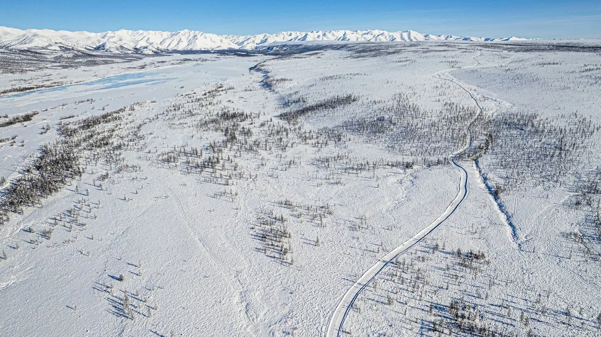 Luftaufnahme einer Winterstraße in der Nähe eines Dorfes als Metapher für die Verbindung von digitaler Sicherheit und lokalem Leben