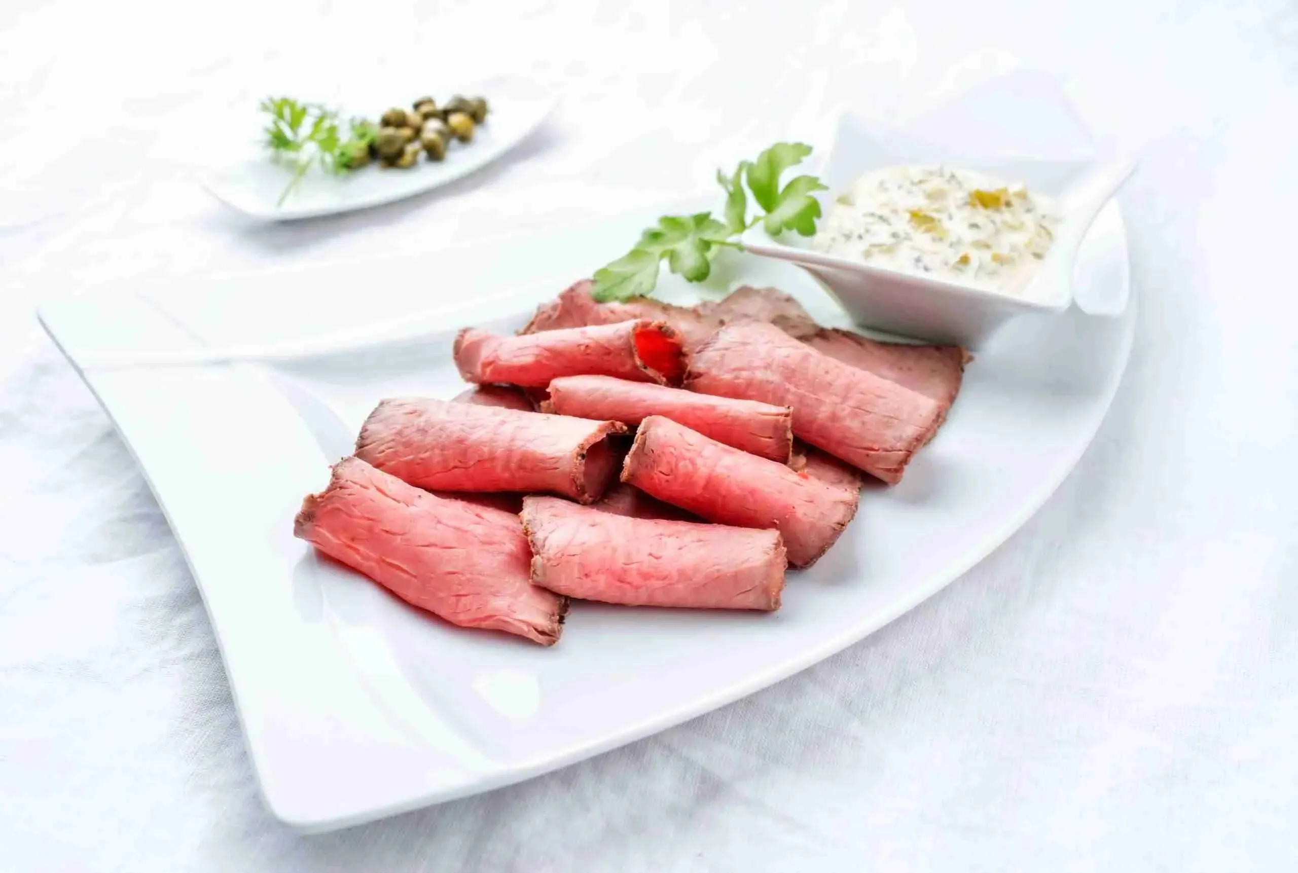 Mahlzeit mit dünn geschnittenem Roastbeef und einer Schale Remoulade