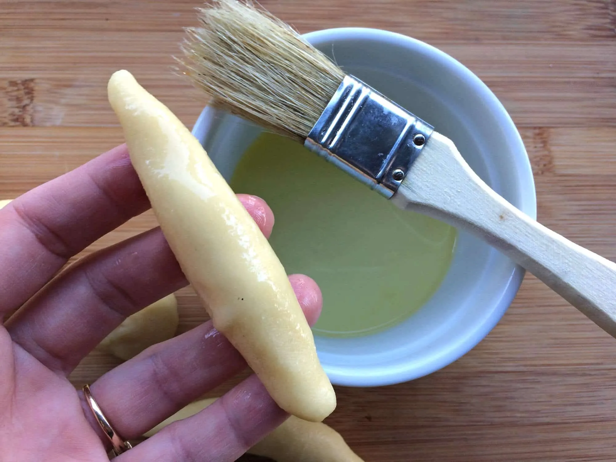 Mandelhörnchen Rohlinge mit Eiweiß bestrichen und bereit zum Wälzen