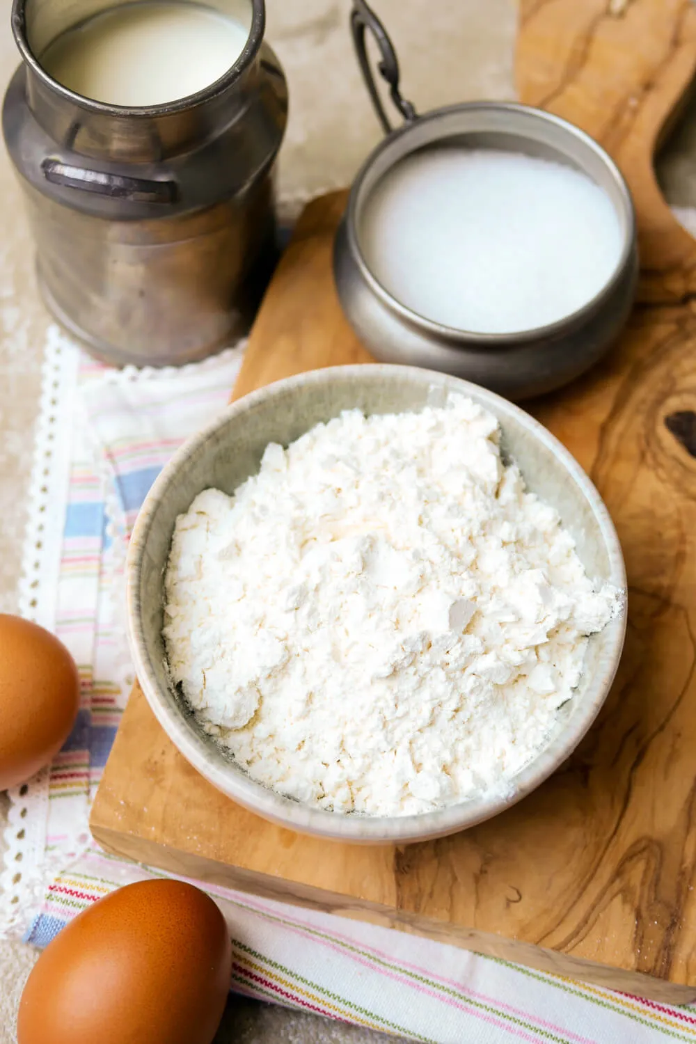 Mehl, Milch, Eier und Zucker in Schüsseln
